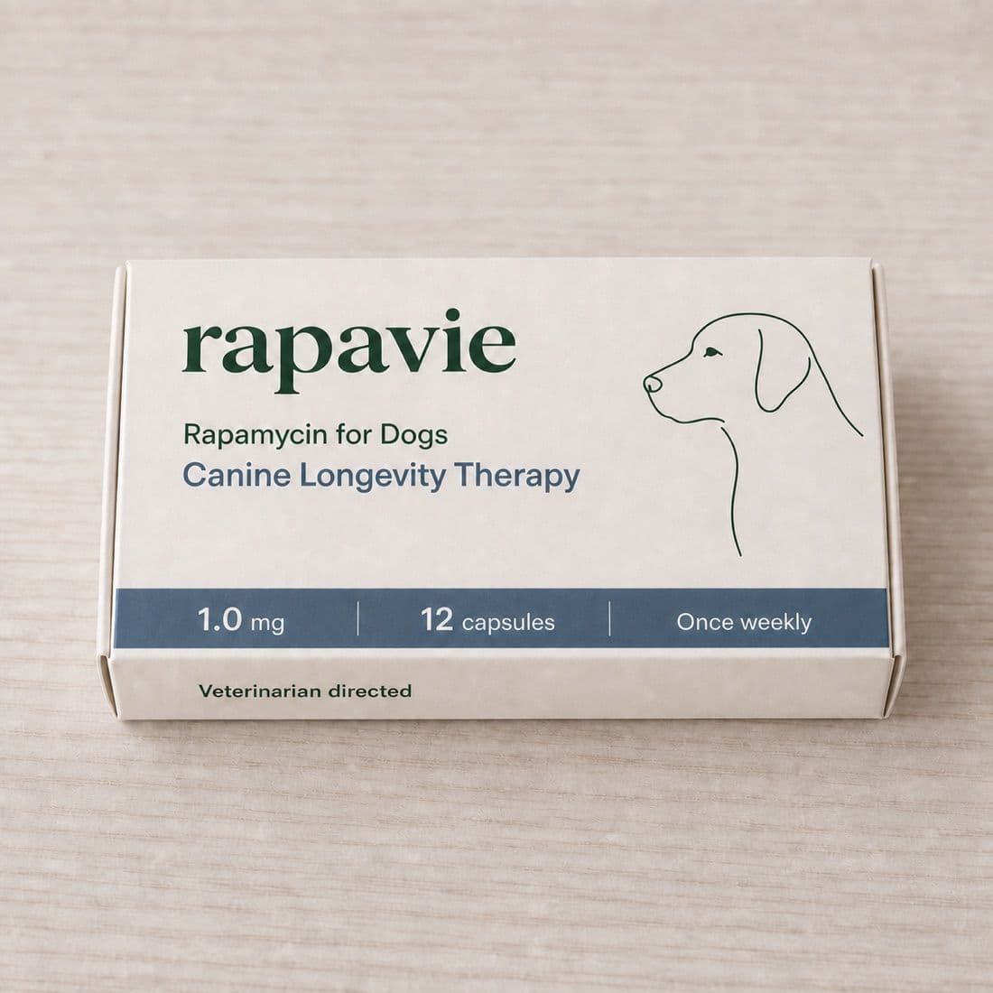The Rapavie dog carton on a pale wooden surface, showing the strength, capsule count and once-weekly schedule
